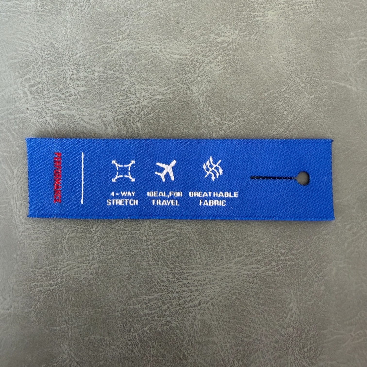 Жакардов тъкан етикет LBL 0043 8 x 2 см – уникален дизайн с отвор за копче, тъкани букви, мек премиум стил, с лого, MOQ 1000 бр Етикети