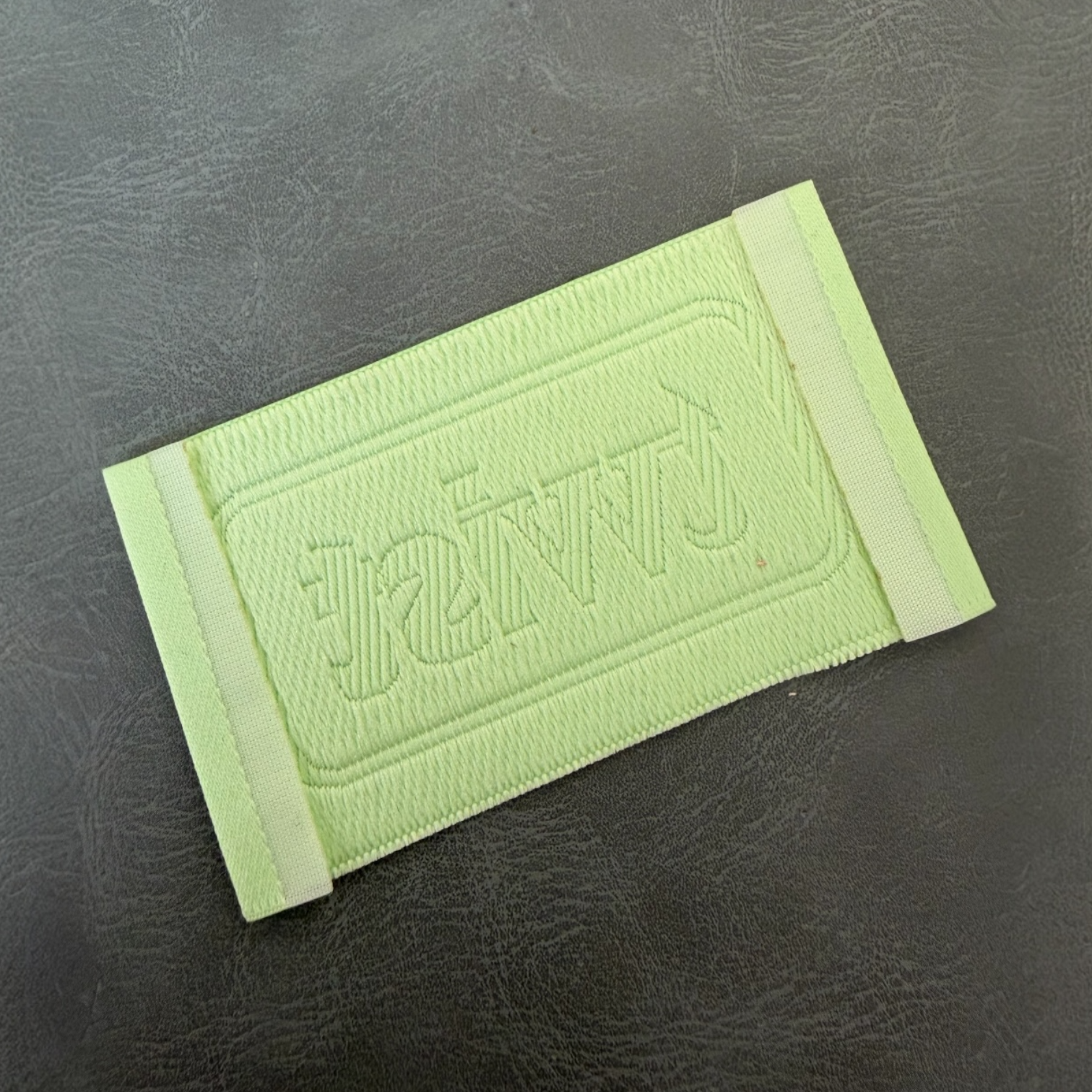 Жакардов тъкан етикет LBL 0050 7 x 4 см – зелен дизайн с релефни букви, мек премиум стил, с лого, MOQ 1000 бр Етикети