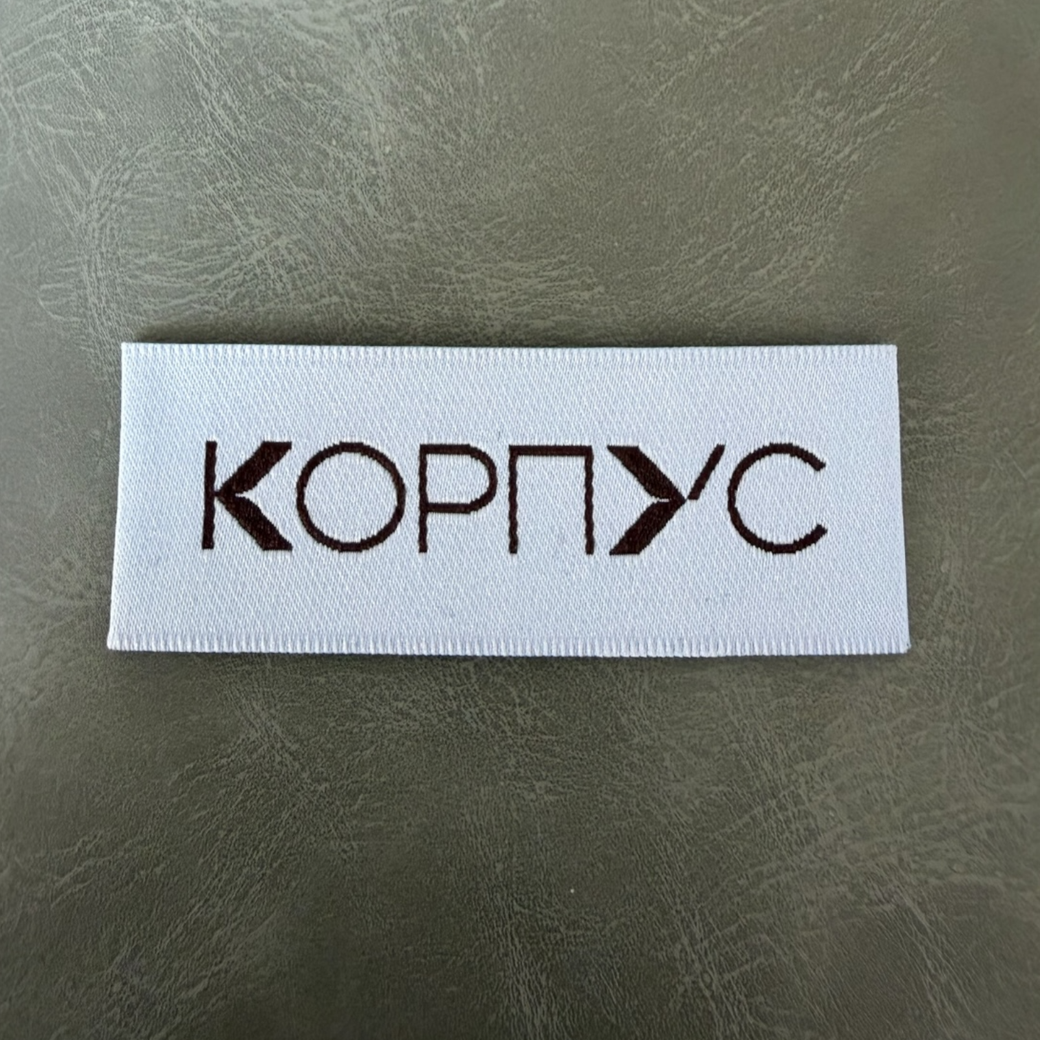 Жакардов тъкан етикет LBL 0053 6.5 x 2.5 см – тюркоаз с кафяви букви, мек премиум дизайн, с лого, MOQ 1000 бр Етикети