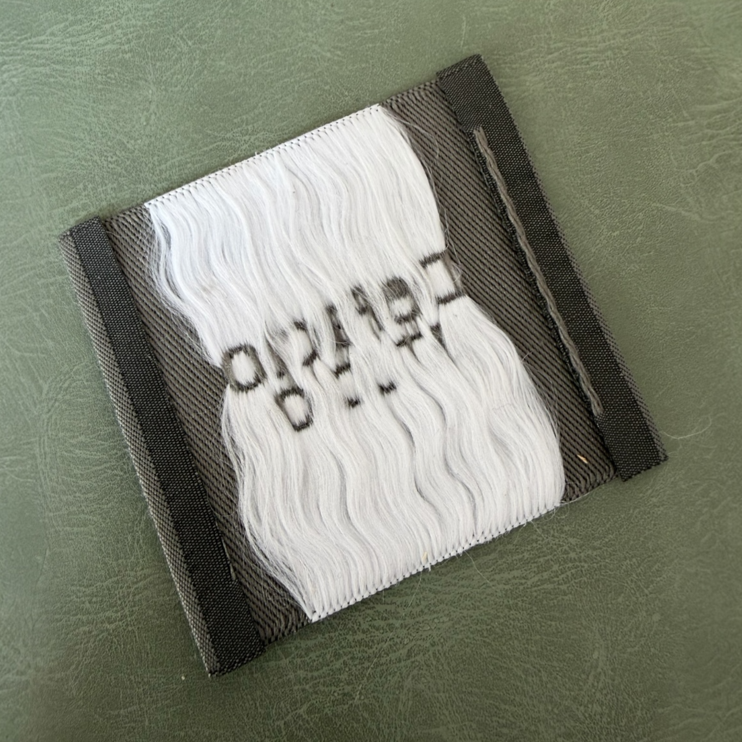 Жакардов тъкан етикет LBL 0056 6.5 x 6 см – сива основа с бели букви, мек премиум дизайн, с лого, MOQ 1000 бр Етикети