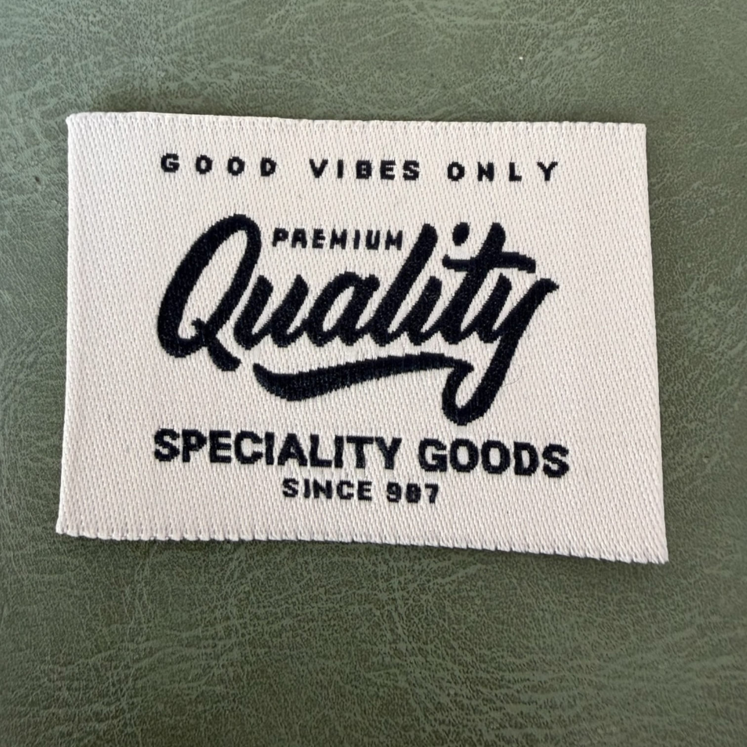 Жакардов тъкан етикет LBL 0059 5 x 3.5 см – бяла основа със сини букви, мек премиум дизайн, с лого, MOQ 1000 бр Етикети