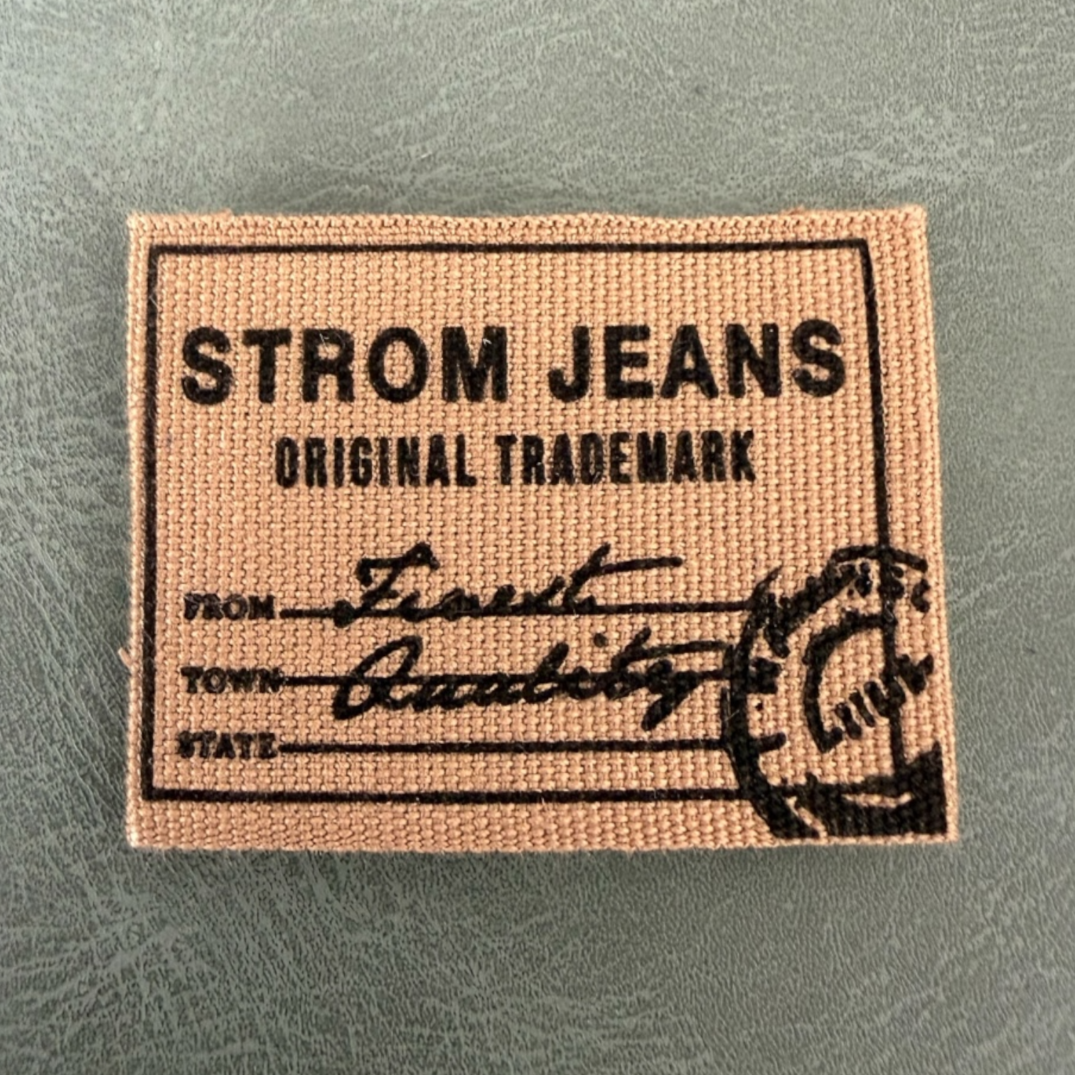 Печатан канвас етикет LBL 0074 4 x 3 см – кафява основа с черен печат, мек премиум дизайн, с лого, MOQ 1000 бр Етикети